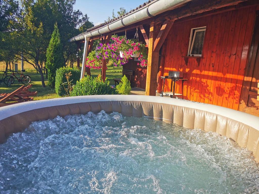 a hot tub in front of a red building at Holiday Home La Sierra in Korenica