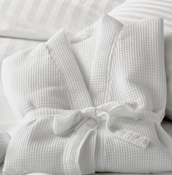 a white blanket with a bow on a bed at Elite Summer Suite in Năvodari