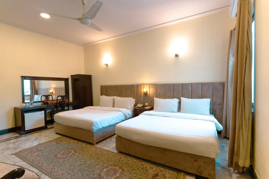 una camera d'albergo con due letti e uno specchio di Renaissance Hotels a Islamabad