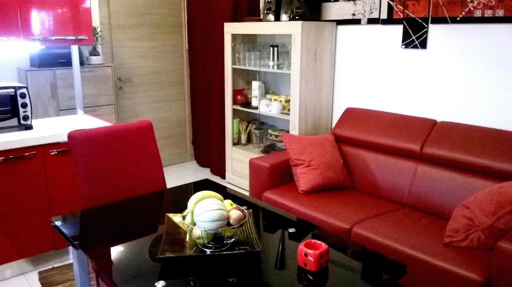 a living room with a red couch and a table at Appartamento Residence Canalotto in Realmonte