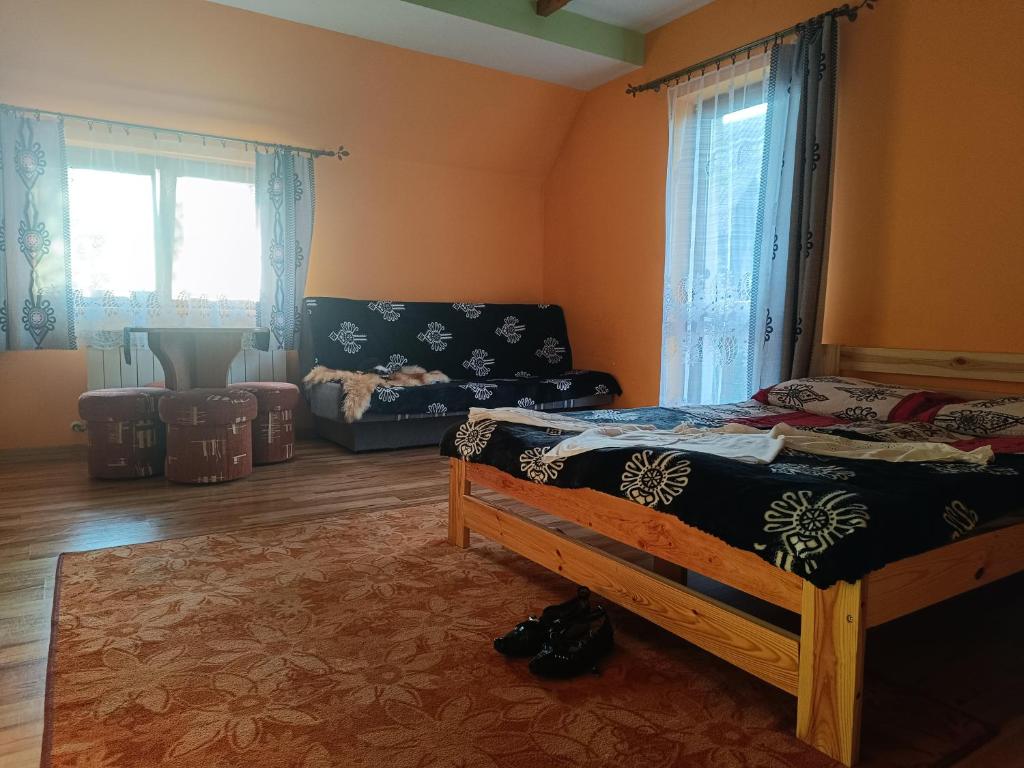 a bedroom with a bed and a couch and windows at Pokoje u Joanny in Ząb