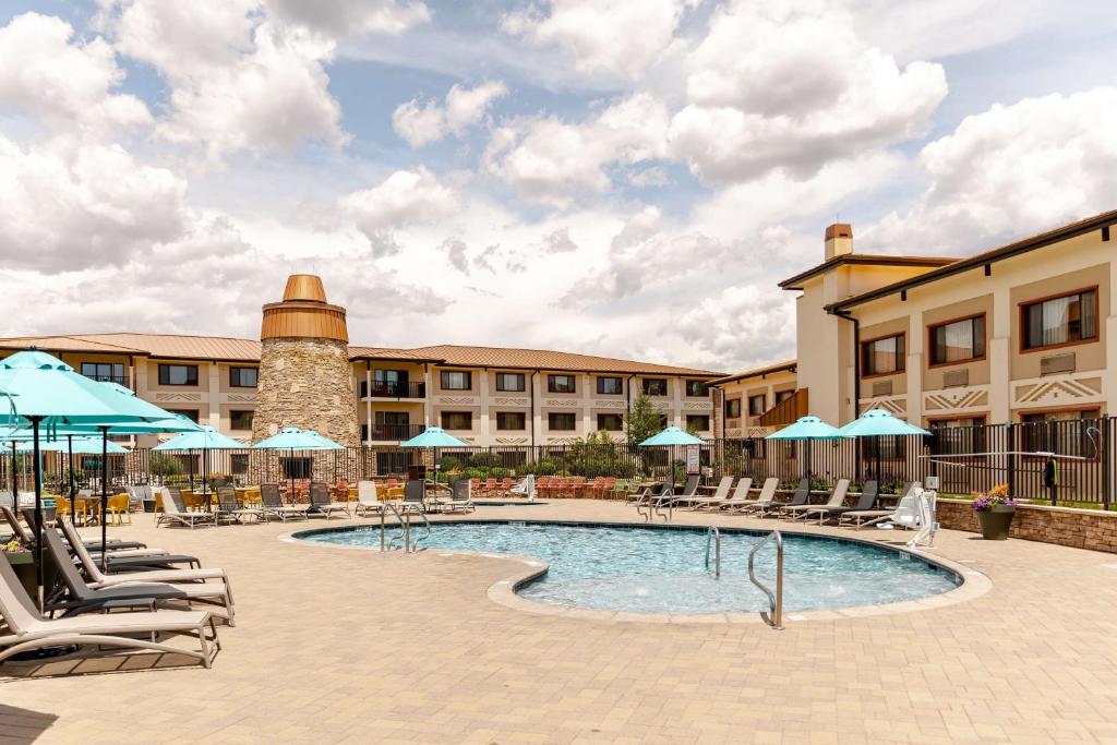 una piscina en un hotel con sillas y sombrillas en Squire Resort at the Grand Canyon, BW Signature Collection, en Tusayan