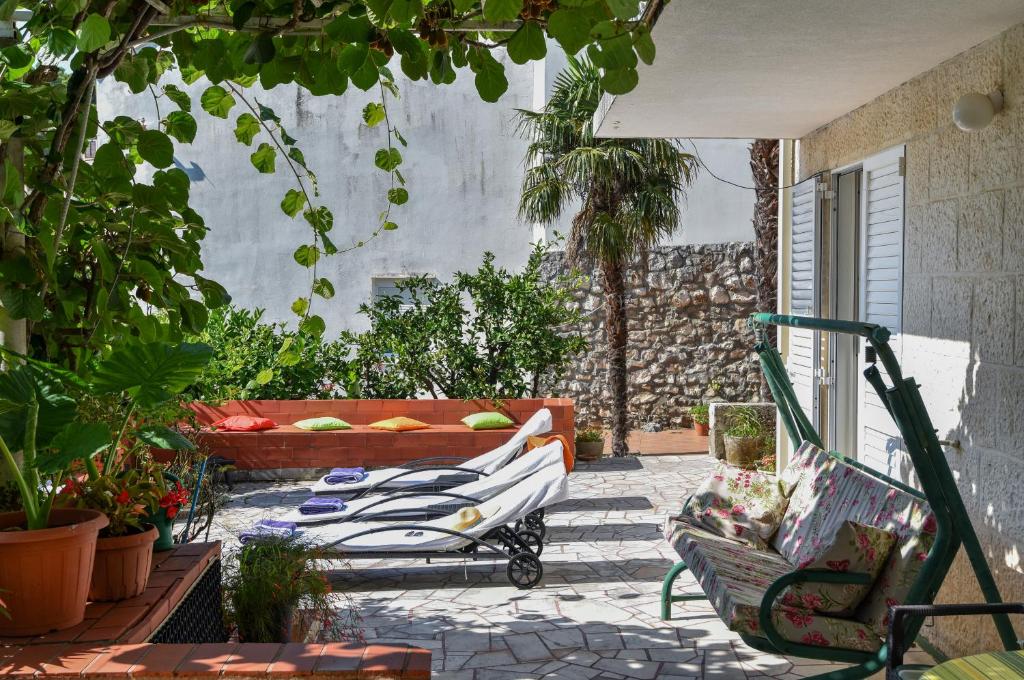 a patio with a couch and chairs and plants at Vizmeg Holiday Home in Dubrovnik