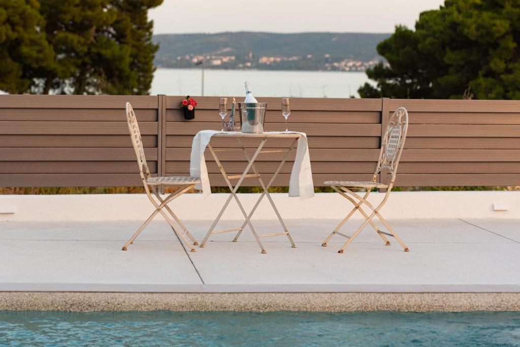 een tafel en stoelen naast een zwembad bij Beach Haven house with pool and Jacuzzi in Kaštela