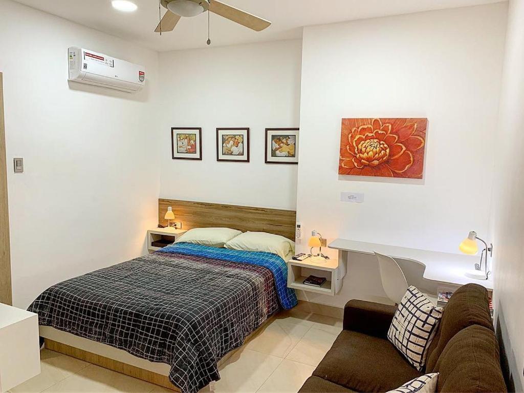 1 dormitorio con cama y escritorio. en Airbnb Urbanor, en Guayaquil