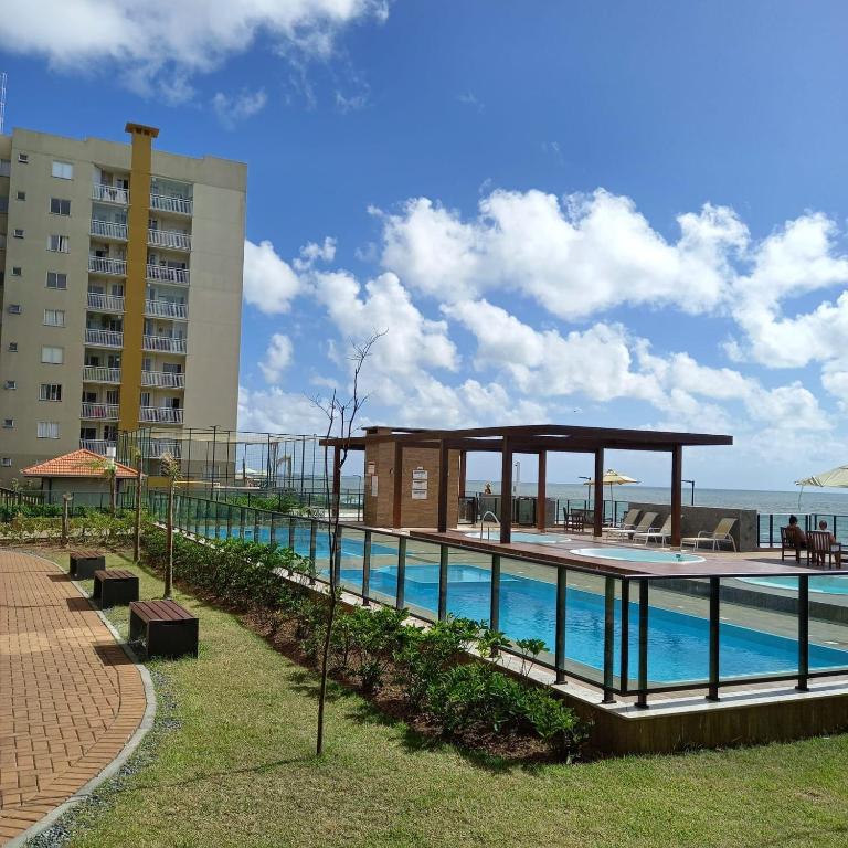 a swimming pool with a pavilion next to a building at Mar com Diversão in Barra Velha