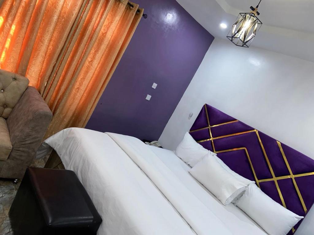 a bedroom with a bed and a purple wall at Bamod Hotel and Suites in Lekki