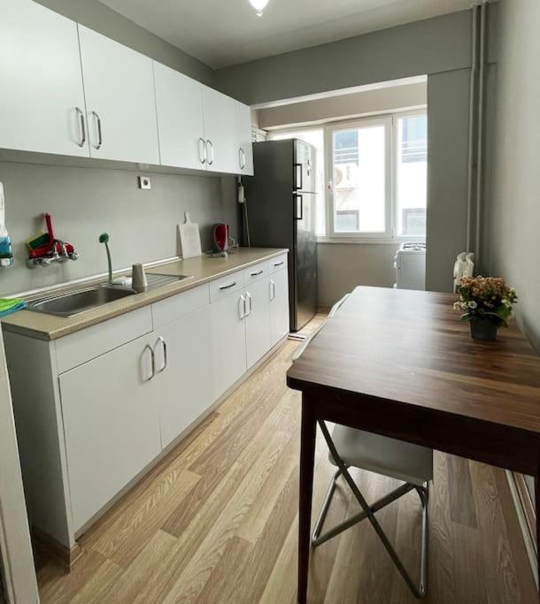 uma cozinha com armários brancos, uma mesa e um frigorífico em Huge Cozy 5+1 Flat em Istambul