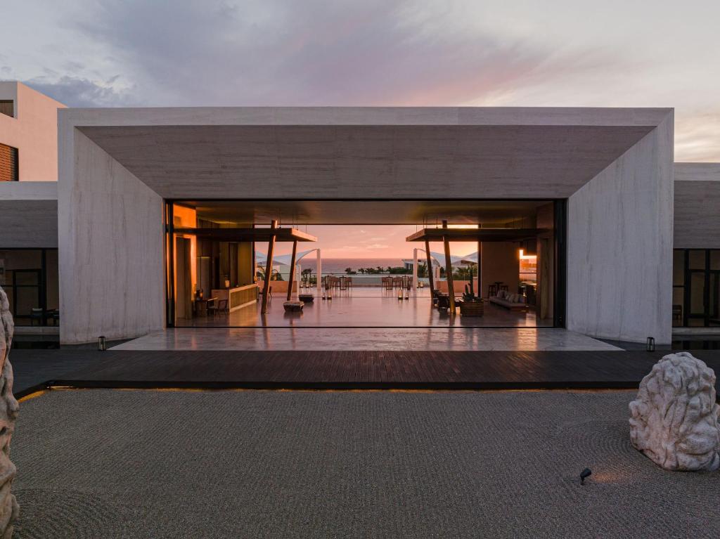 a large building with a sunset in the background at Nobu Hotel Los Cabos in Cabo San Lucas