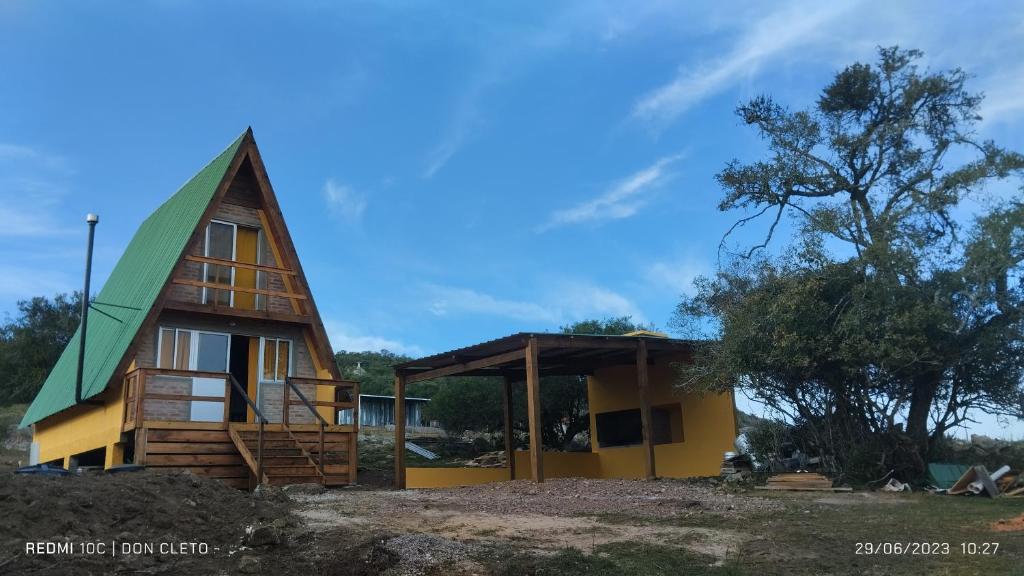 una pequeña casa con techo verde en Don Cleto en Aiguá