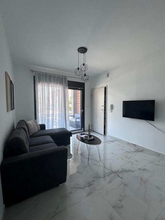 a living room with a couch and a table at ἕαR Exceptional Residence in Nea Peramos