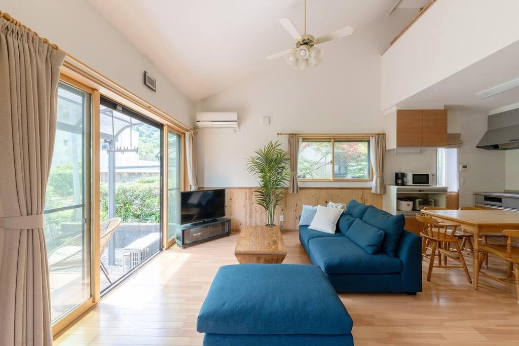 ein Wohnzimmer mit einem blauen Sofa und einem Tisch in der Unterkunft Seaside Villa Nagi in Maizuru