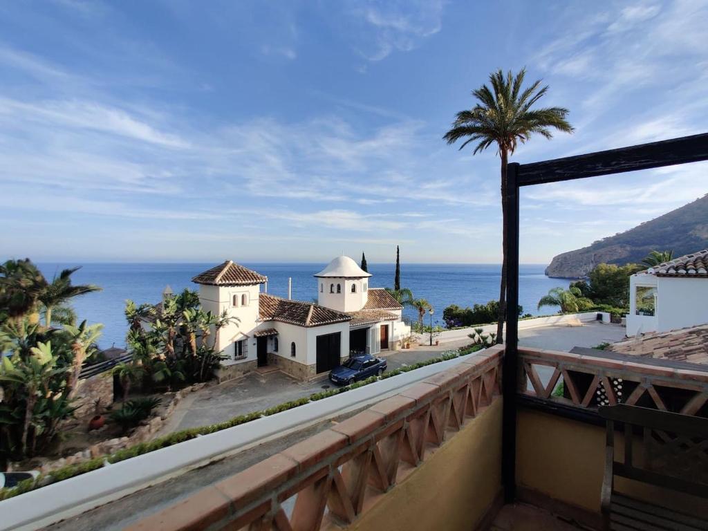 a view from the balcony of a house with a palm tree at Casa Junto al Mar in La Herradura