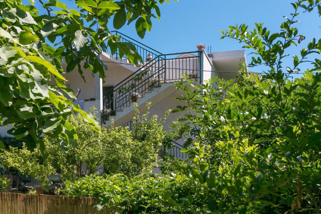 ein Gebäude mit einer Treppe inmitten von Bäumen in der Unterkunft Apartments with a parking space Kastel Stafilic, Kastela - 20802 in Kaštela