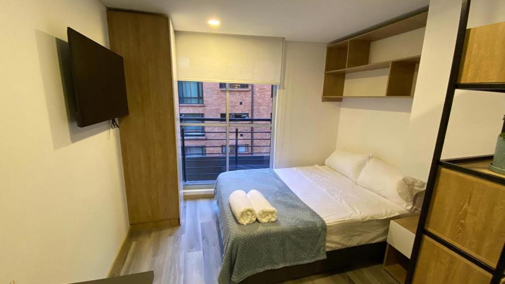 - une petite chambre avec un lit et une fenêtre dans l'établissement APARTAMENTO CABRERA 85.12, à Bogotá