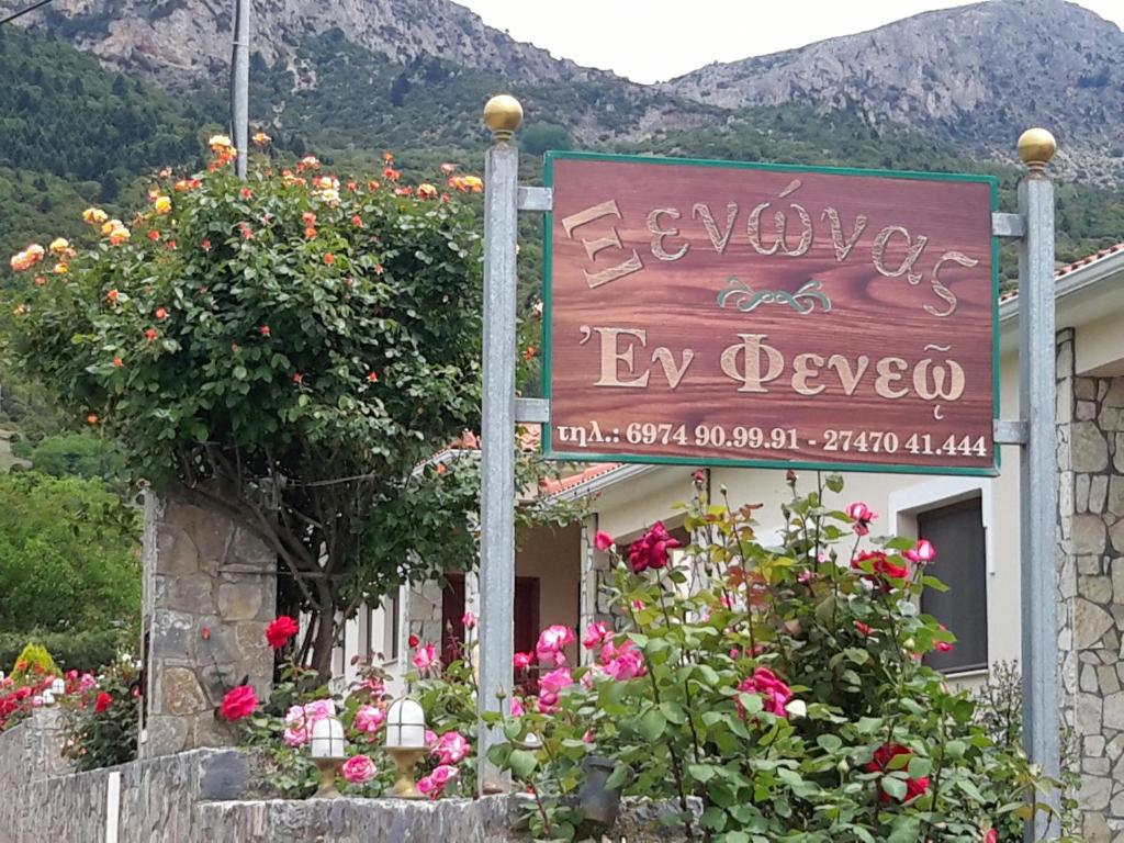 a sign in front of a building with flowers at En Feneo in Mesinón