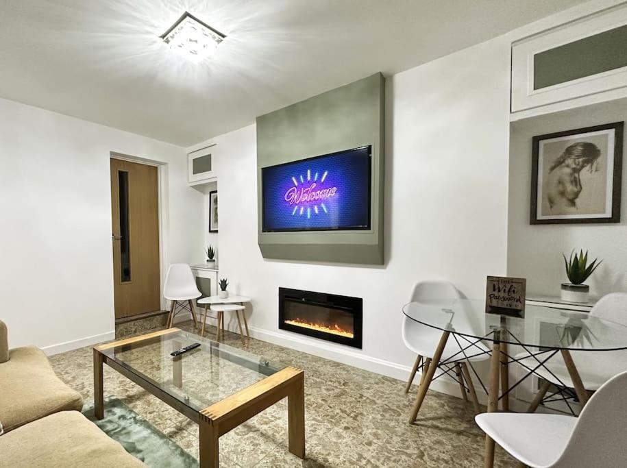 a living room with a couch and a fire place at Fabulous Fiery Flat w/ body shower - Tylorstown in Llwyn-y-pia