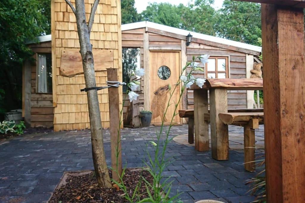 a garden with a bench and a building at Charming 2-Bed Cabin in Sutton Coldfield in Sutton Coldfield