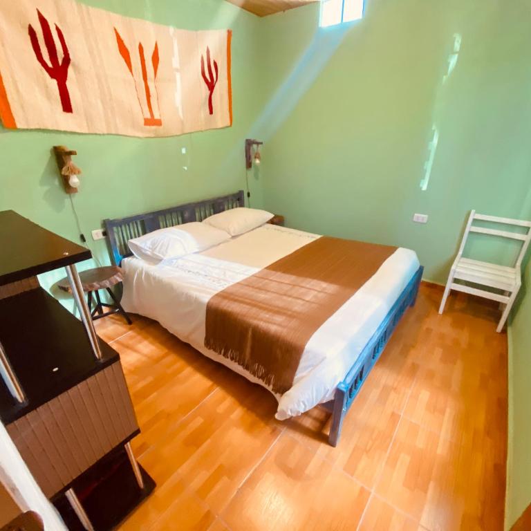 a bedroom with a bed and a table and a chair at Casa TAQI in San Pedro de Atacama