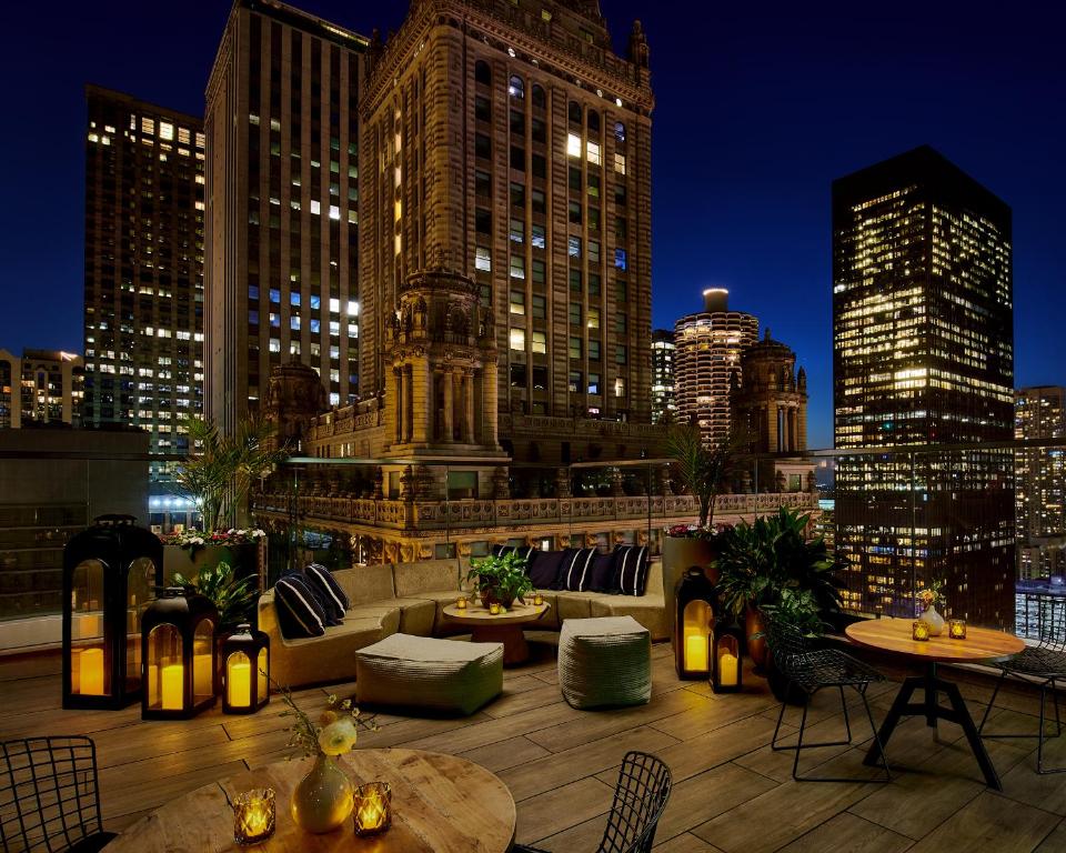 a rooftop patio with a view of a city at night at Virgin Hotels Chicago in Chicago