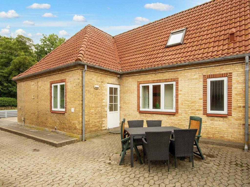 einen Tisch und Stühle vor einem Backsteinhaus in der Unterkunft Holiday home Højer III in Højer