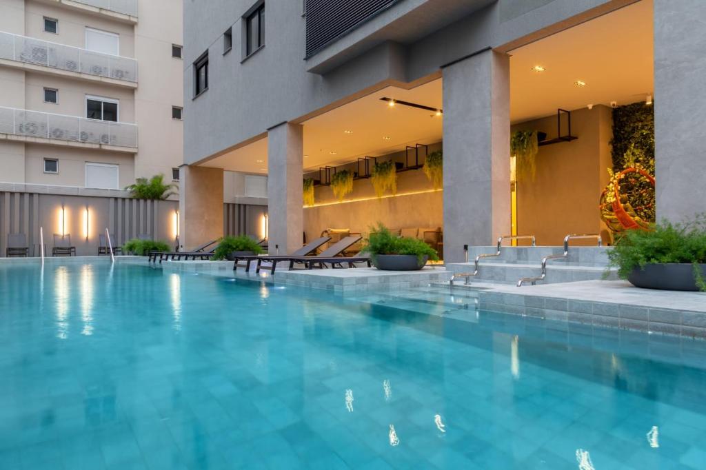 uma piscina em frente a um edifício em I Am Design Hotel Itapema by Hotelaria Brasil em Itapema