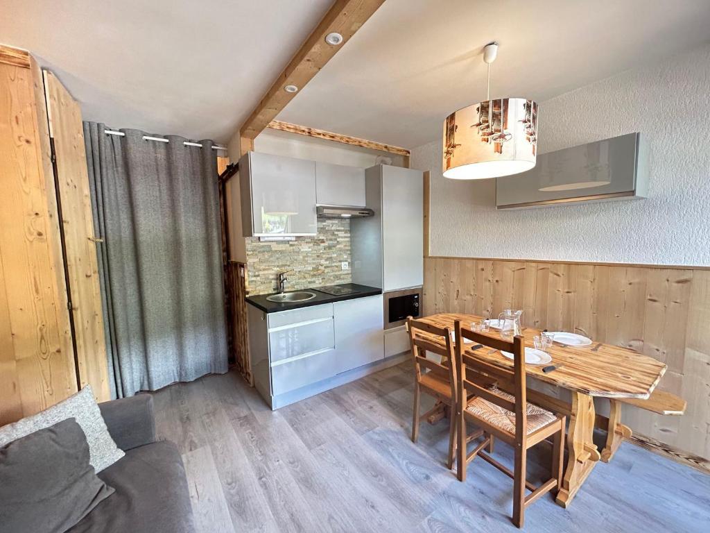 une cuisine avec une table en bois et une salle à manger dans l'établissement Studio rénové aux pieds des pistes des Chavannes, cœur de station, balcon, 4 couchages - FR-1-623-260, aux Gets