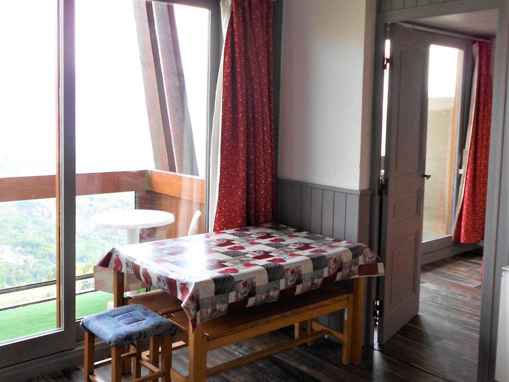 une table et des chaises dans une pièce avec une fenêtre dans l'établissement Appartement lumineux · Pied des pistes · Double balcon · WIFI gratuit · Piscine incluse - FR-1-267-253, à Villarembert