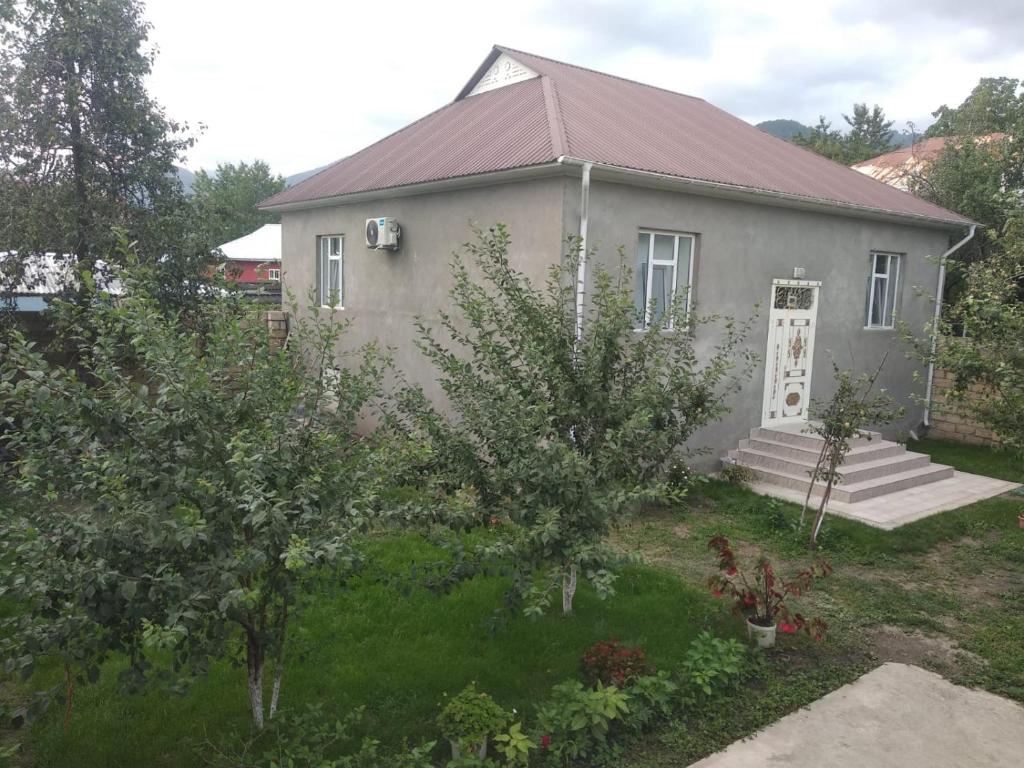 a house with a yard with trees and bushes at Elchins villa in Gabala