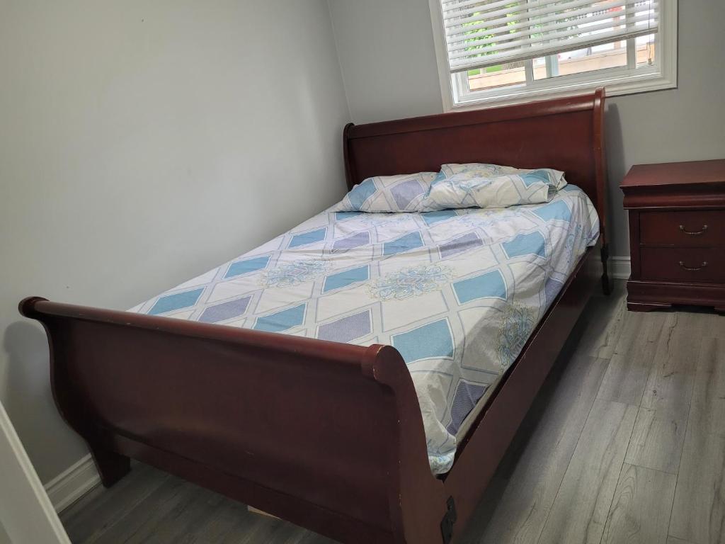 a bed in a bedroom with a wooden floor at Individual home in Brampton