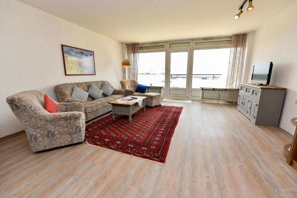 a living room with a couch and a tv at Haus "Panorama" Appartement PAN105 in Duhnen