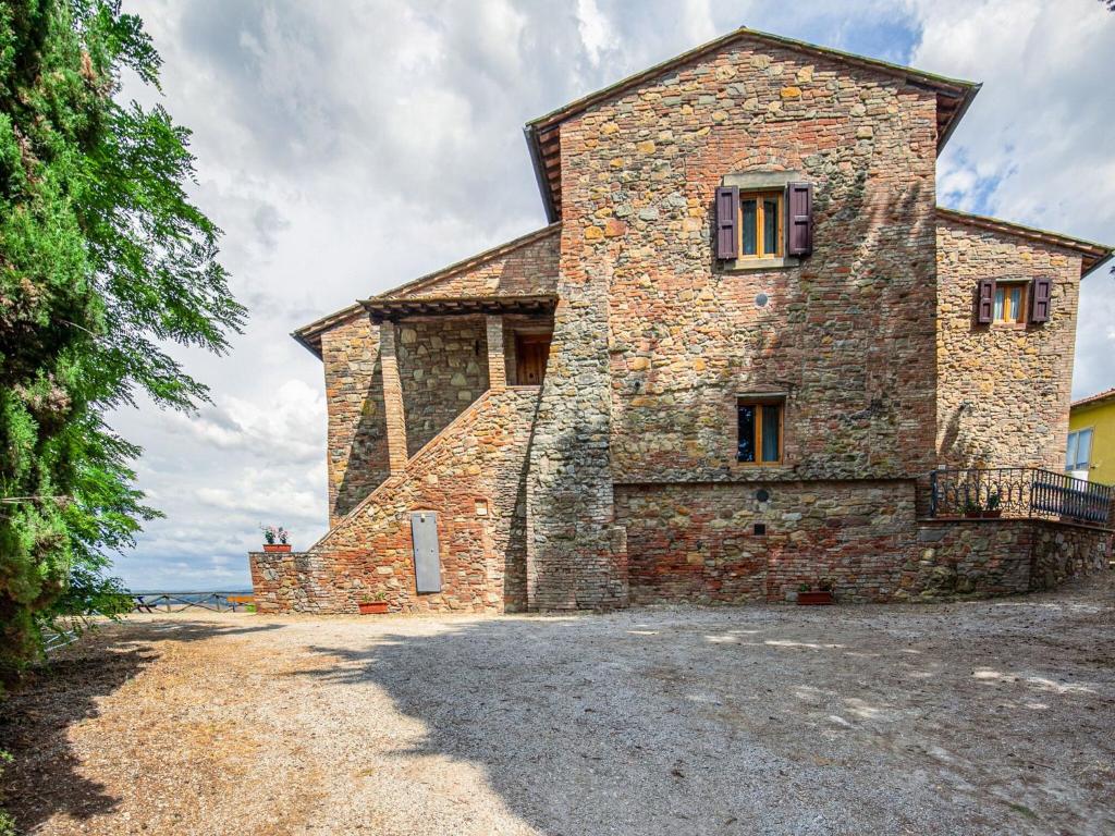un gran edificio de piedra con una ventana en él en Idyllic Farmhouse in Gambassi Terme Fi with Swimming Pool, en Querce