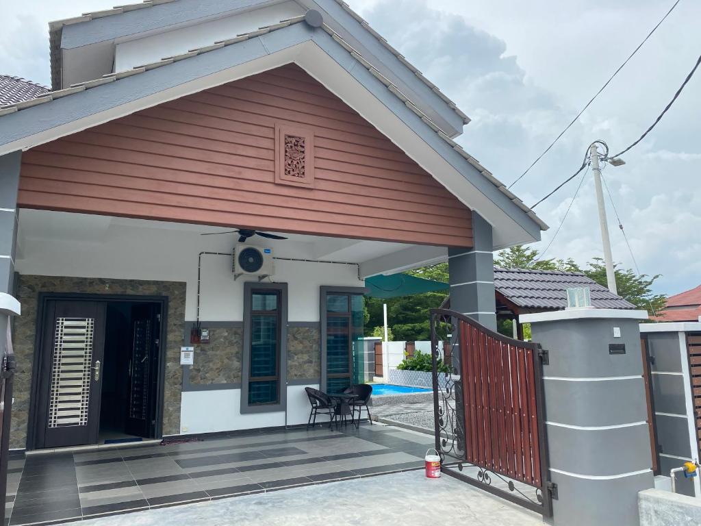 a house with a gate and a porch at NS Vacation Home Muar with Kids Friendly Pool in Muar