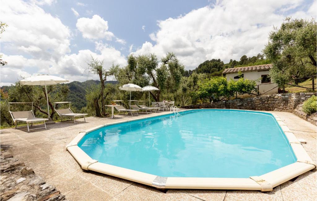 una grande piscina blu con sedie e ombrelloni di Villa Bianca E Metato a Gello