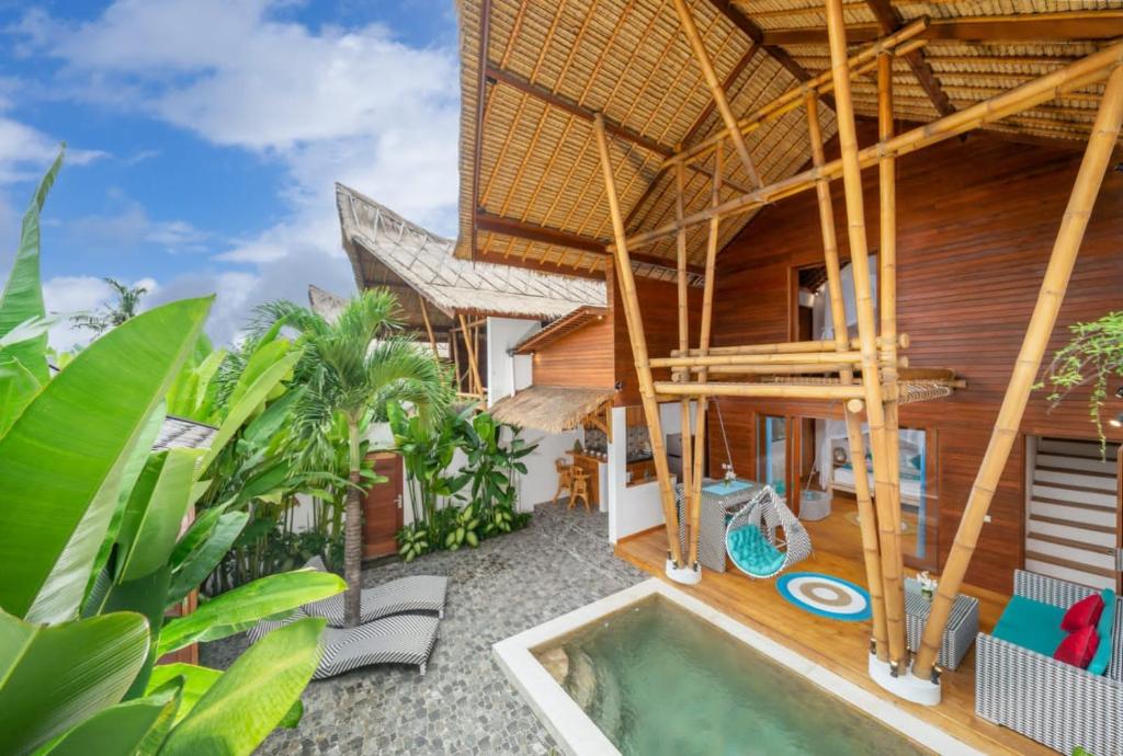 una casa con una piscina di fronte di The Secret Jungle Villas Berawa a Canggu