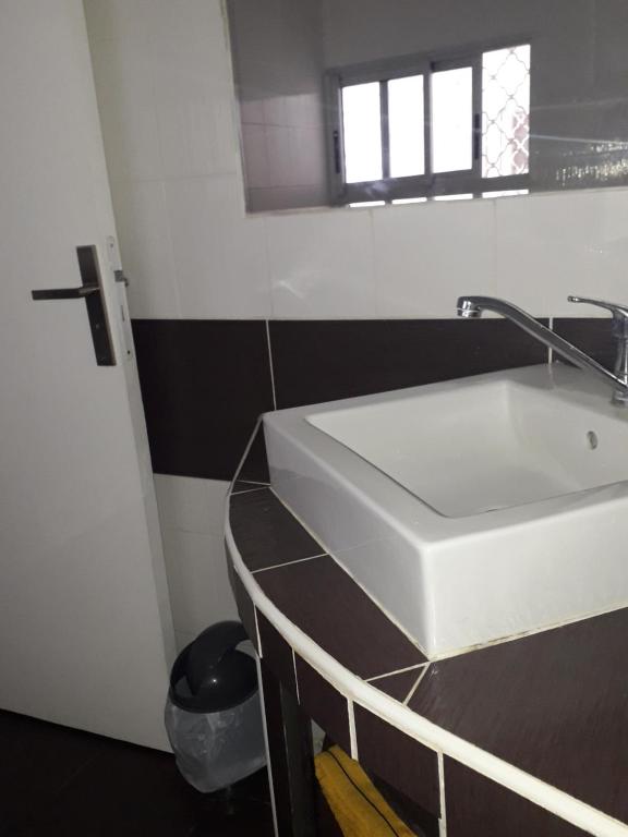 a bathroom with a white sink and a window at La Cas'Aline in La Saline les Bains