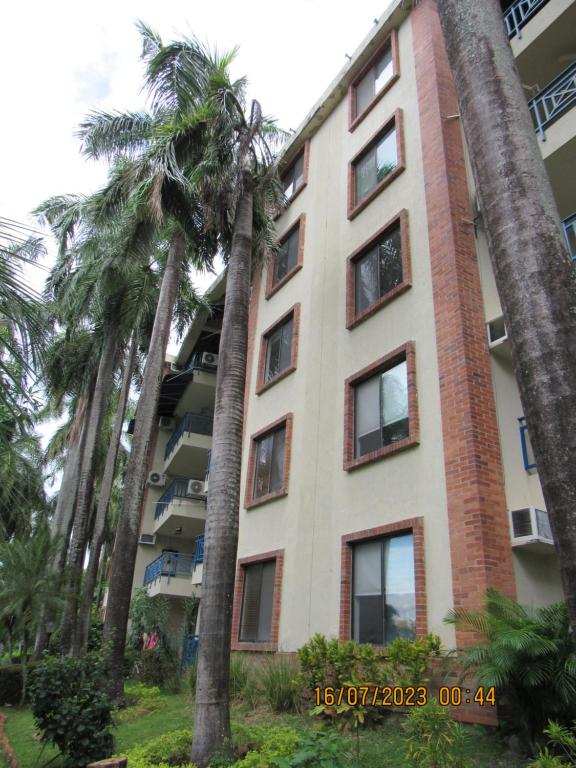 a tall building with palm trees in front of it at Condominio Girardot Resort INT 4 APTO 302 in Girardot