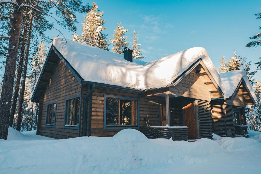 Cabaña de madera con nieve en el techo en Kantokelo, en Ylläsjärvi