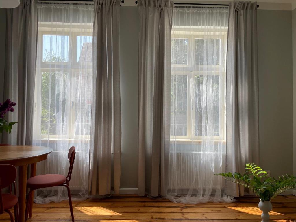 a room with two large windows with white curtains at Harry Hans Beach Apartment in Pärnu