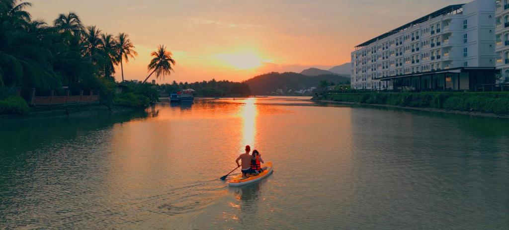 two people in a boat on a river at sunset at Champa Island Nha Trang - Resort Hotel & Spa in Nha Trang