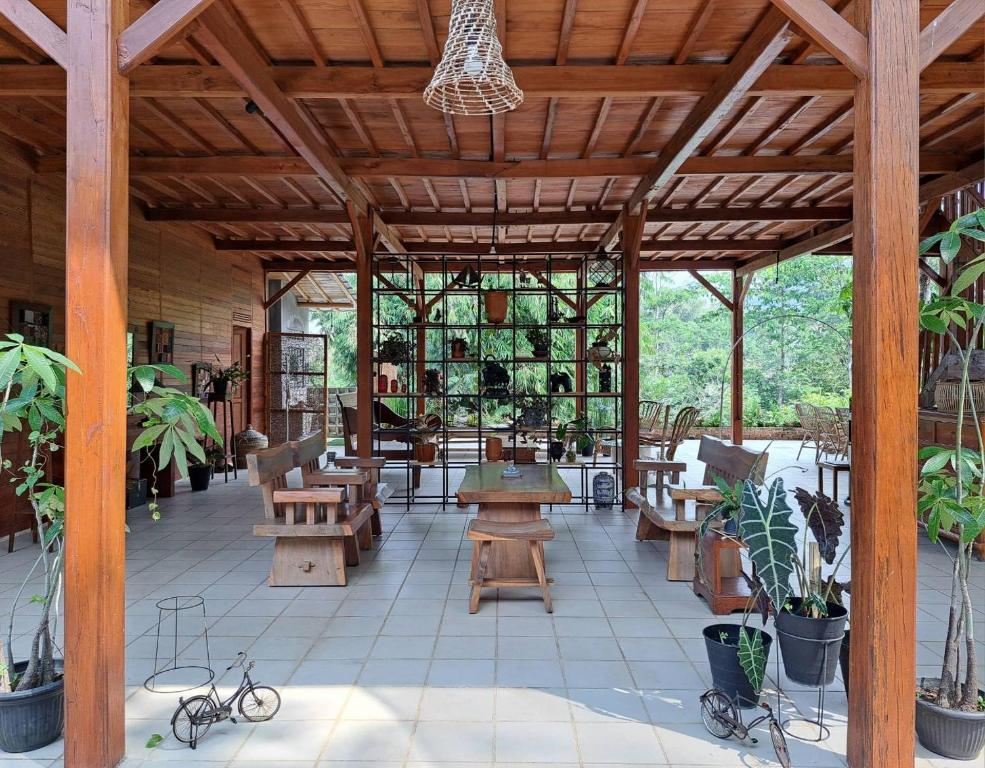 um pavilhão com mesas e bancos de madeira e plantas em Juar House em Simpen