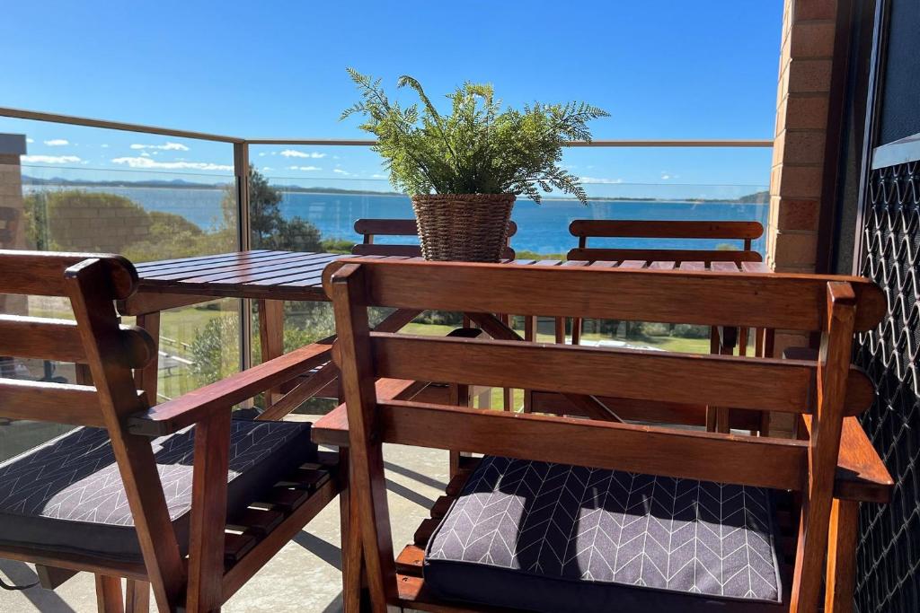 a balcony with a table and a potted plant on it at Promenade, 12 8 Intrepid Cl - fantastic waterfront unit with air con and WiFi in Nelson Bay