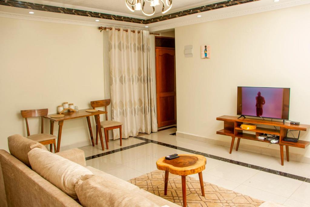 uma sala de estar com um sofá e uma televisão em BRB Homes - Spacious 1 Bedroom Apatment - Bukoto, Kampala em Kampala