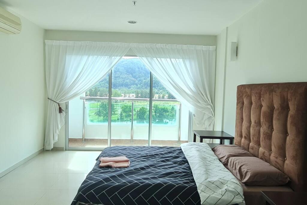 een slaapkamer met een bed en een groot raam bij D'Sea Marina Island Resort by Manhattan Group in Lumut