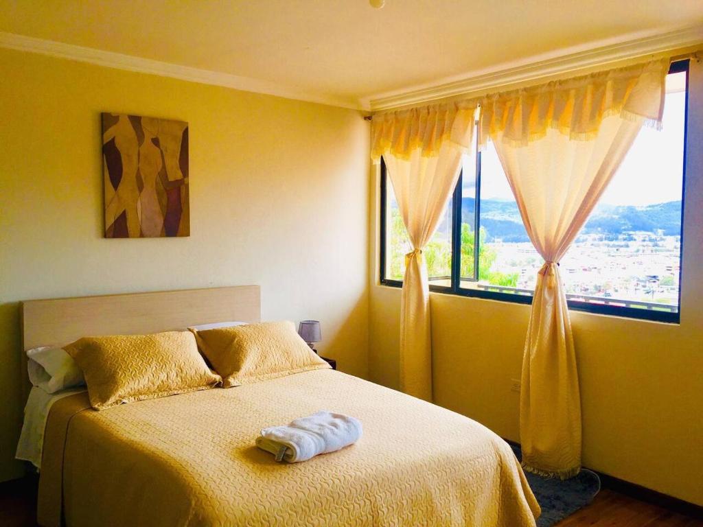 a bedroom with a bed and two windows at View n Wide/Green Place in Cuenca