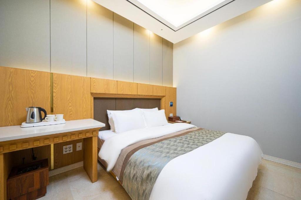 a hotel room with a bed and a desk and a bed sidx sidx at Hotel Core in Naju