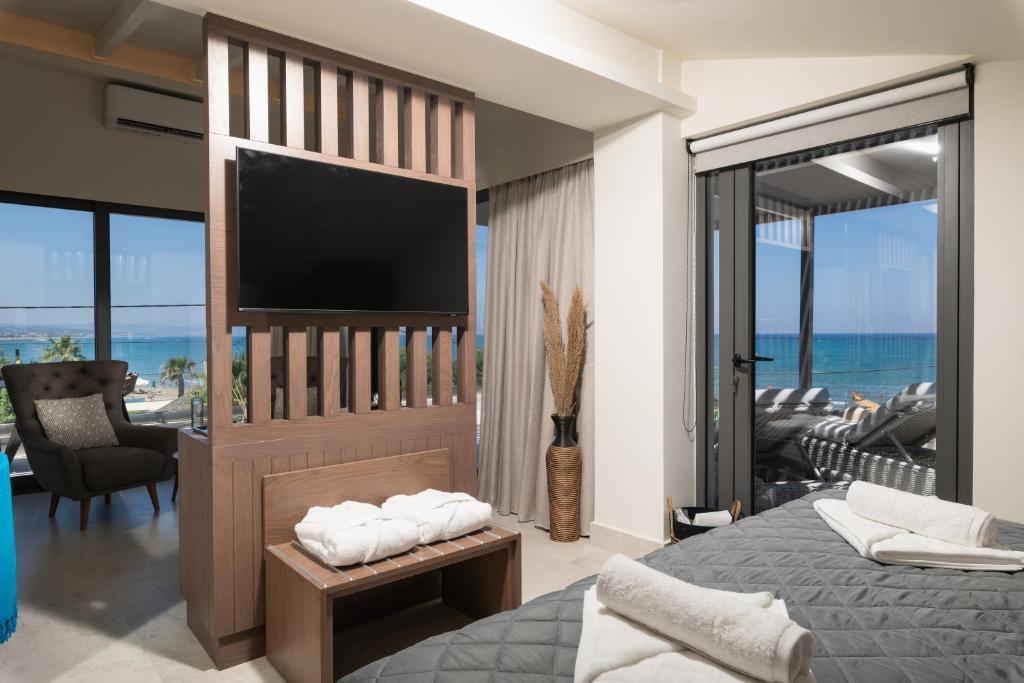een slaapkamer met een flatscreen-tv en een bed bij Elia Agia Marina Resort in Agia Marina Nea Kydonias