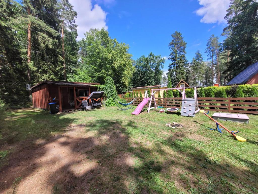 einen Hof mit Spielplatz und Schuppen in der Unterkunft Domek Drewniany w Dolinie Symsarny in Lidzbark Warmiński