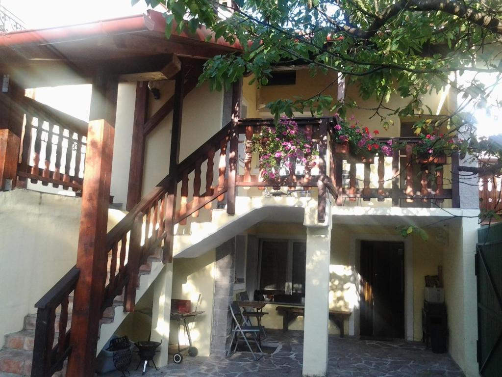 un balcón de una casa con una mesa y flores en Apartments Hemingway House, en Kobarid