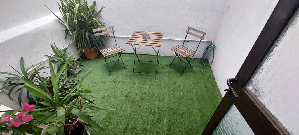 two chairs and a table in a room with plants at Cosy and roomy 78m2(Μονοκατοικία) in Piraeus